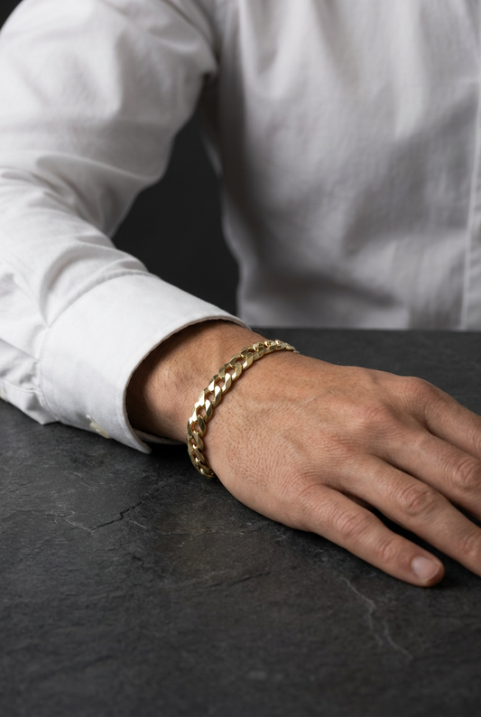 Original gold bracelet styled with a white shirt and dark stone background