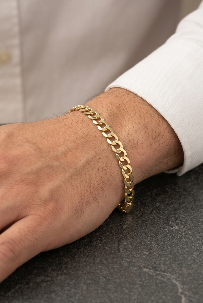 Original gold curb-link bracelet on a male model’s hand and wrist